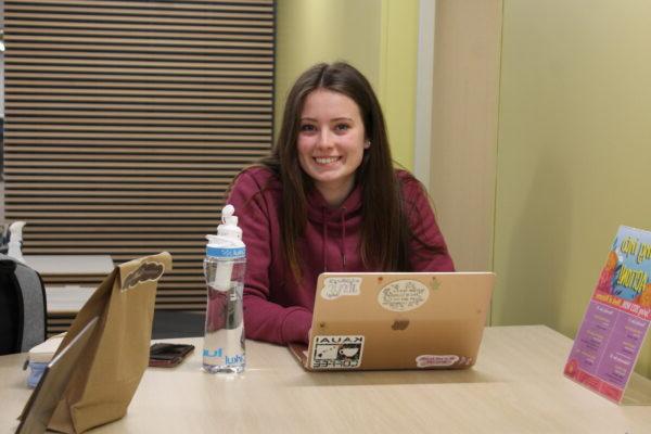 a person sitting at a table with a laptop